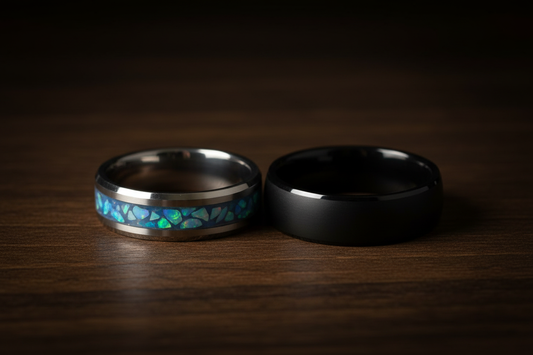 Two handcrafted tungsten and ceramic wedding rings on dark wood — alternative wedding bands for couples, WildBeard Legacy Co.