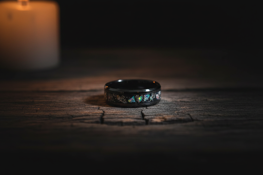 Handcrafted black ceramic memorial ring with opal ash inlay on dark wood — WildBeard Legacy Co., Fort Collins, CO