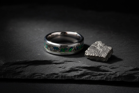 Handcrafted black ceramic meteorite ring beside raw Gibeon meteorite — what is meteorite inlay jewelry, WildBeard Legacy Co.