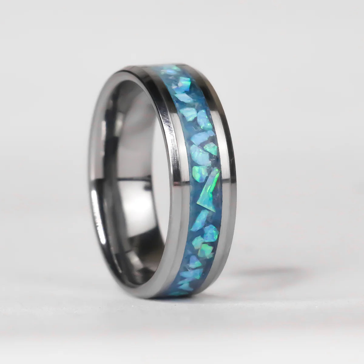 Silver ring with blue opal inlay on a white background