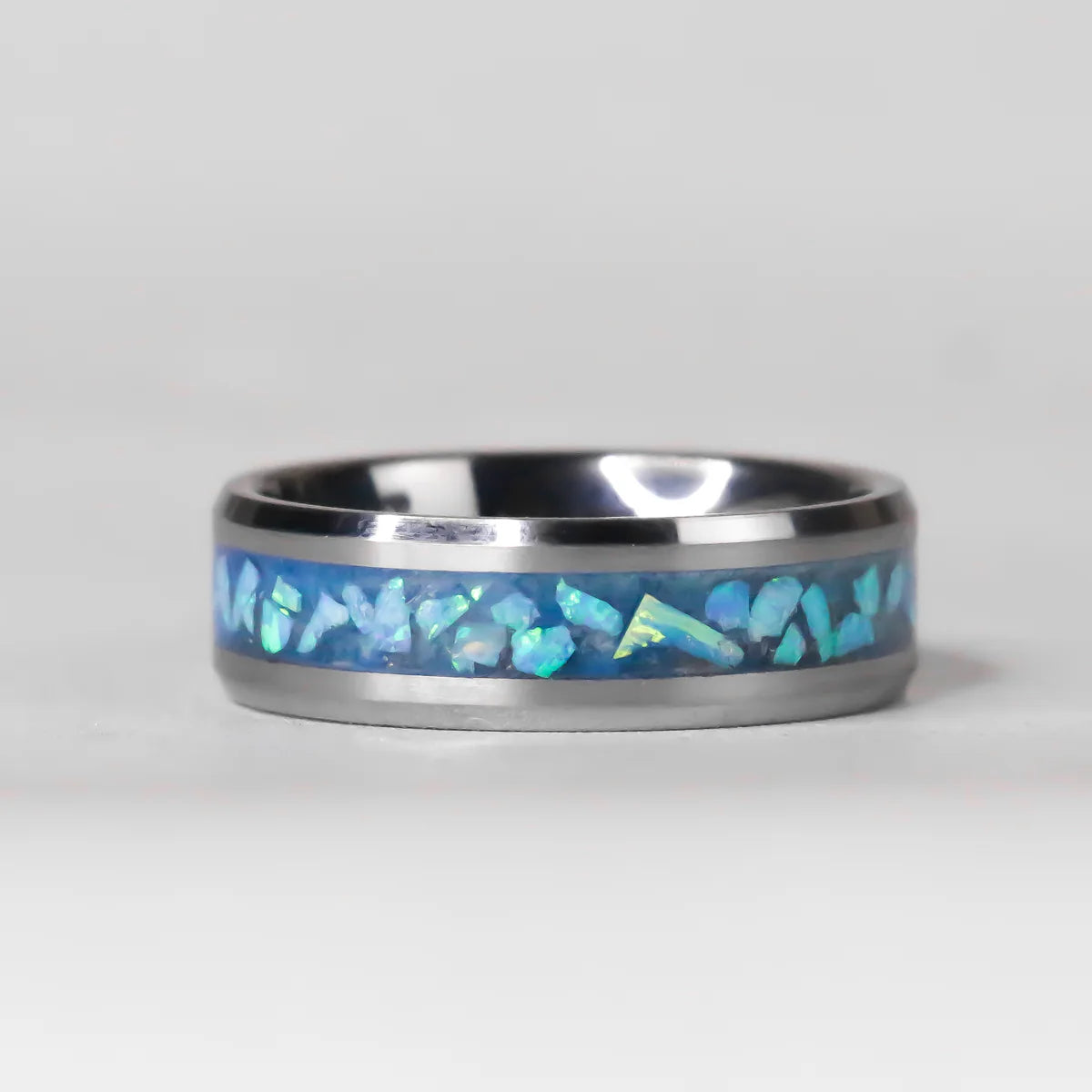 Silver ring with blue opal inlay on a gray background