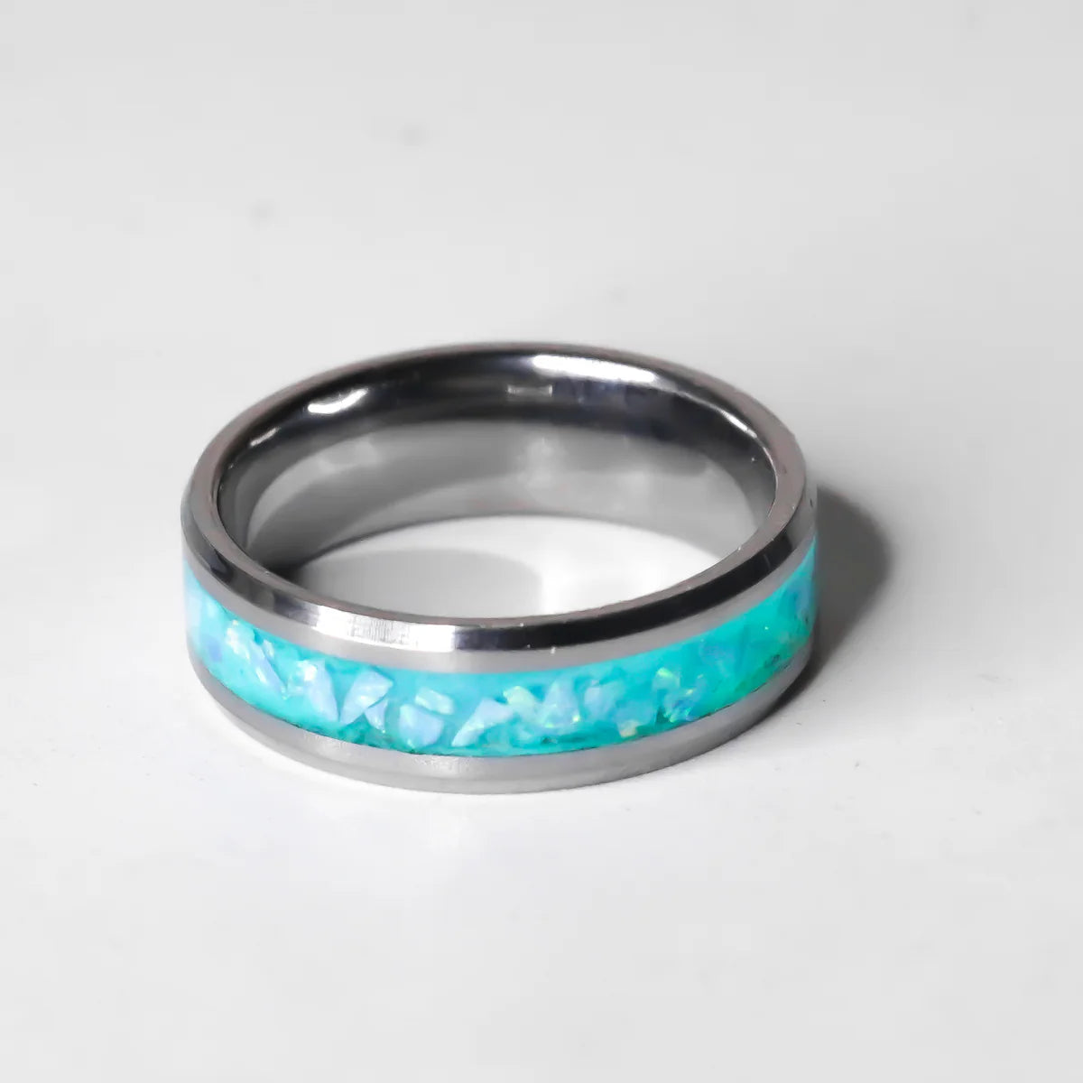 Silver ring with a turquoise inlay on a white background
