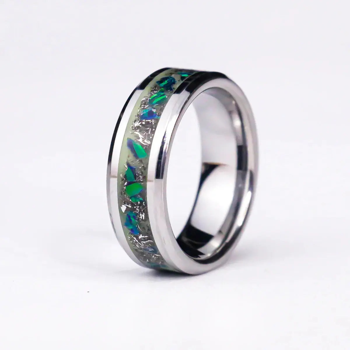 Silver ring with embedded green and blue stones on a white background
