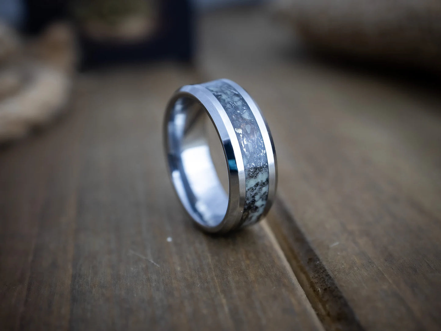 Silver ring with a textured band on a wooden surface