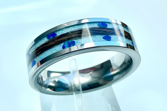 Titanium ring with light blue and white powder base, black and brown horsehair, and navy-blue opal stones